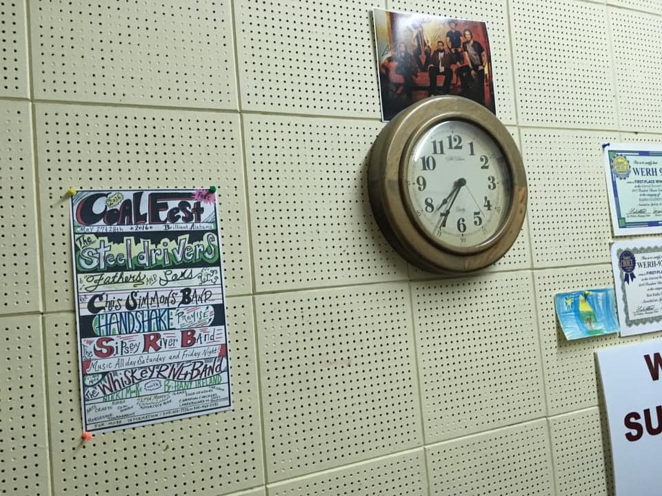 Clock and concert poster on a WERH wall