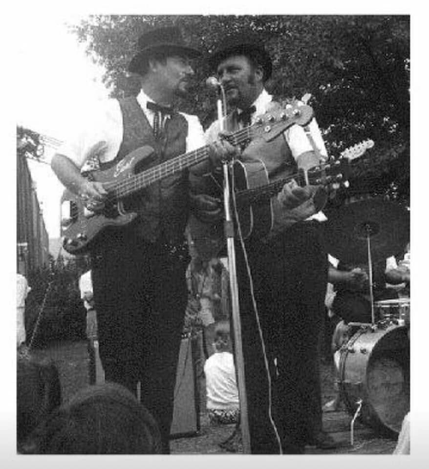 Two country musicians performing together with guitars